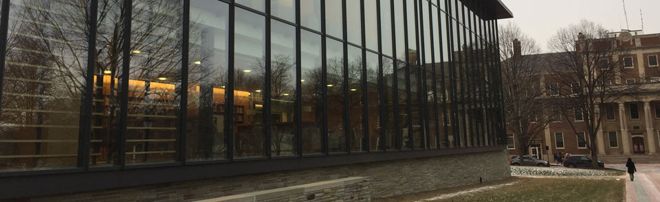 The glass-fronted windows of Skillman Library reflect the evening light.