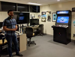 Man standing in a room with gaming consoles