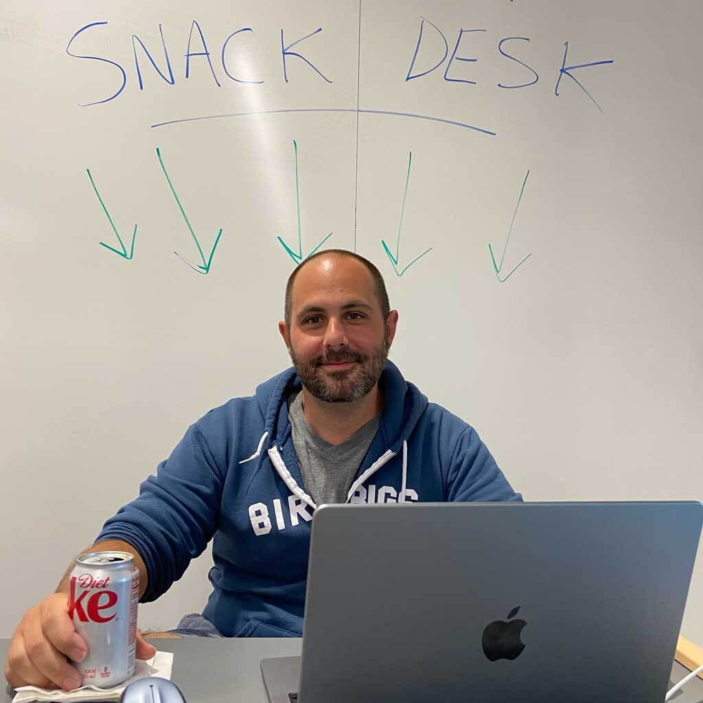 Smiling man with can of Diet Coke and Mac laptop